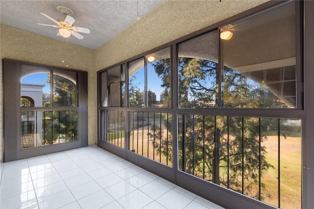 unfurnished sunroom with a ceiling fan