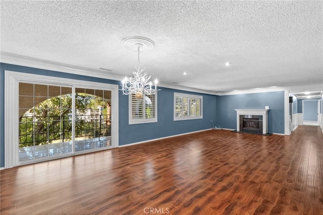 unfurnished living room featuring baseboards, wood finished floors, a glass covered fireplace, and crown molding