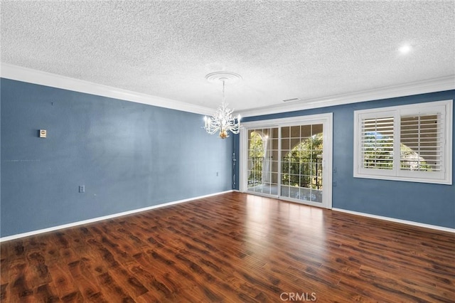 unfurnished room featuring ornamental molding, a notable chandelier, baseboards, and wood finished floors