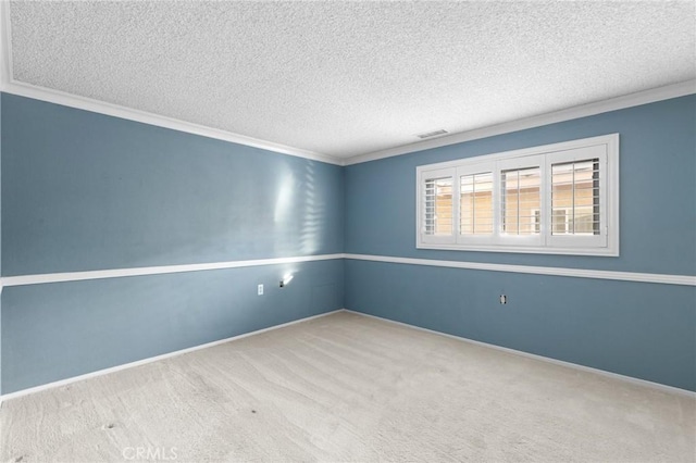 unfurnished room with visible vents, carpet flooring, a textured ceiling, and baseboards