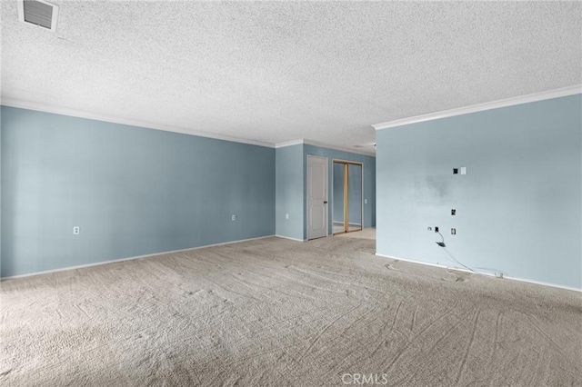 empty room with carpet, visible vents, a textured ceiling, and ornamental molding