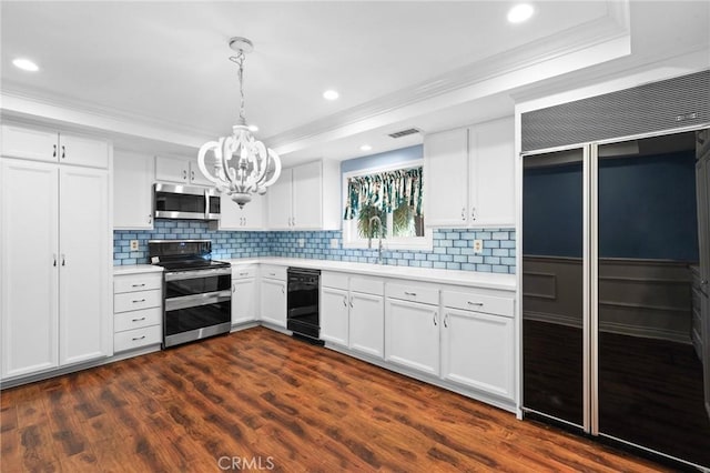 kitchen with appliances with stainless steel finishes, light countertops, and a tray ceiling