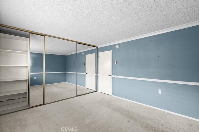 unfurnished bedroom with a textured ceiling, a closet, carpet flooring, and crown molding