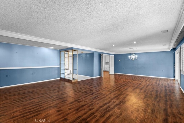 unfurnished living room featuring a chandelier, a textured ceiling, wood finished floors, and baseboards