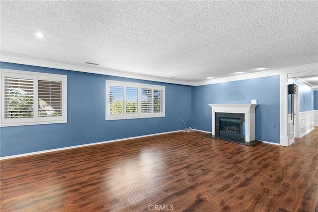 unfurnished living room featuring ornamental molding, dark wood-type flooring, and a textured ceiling