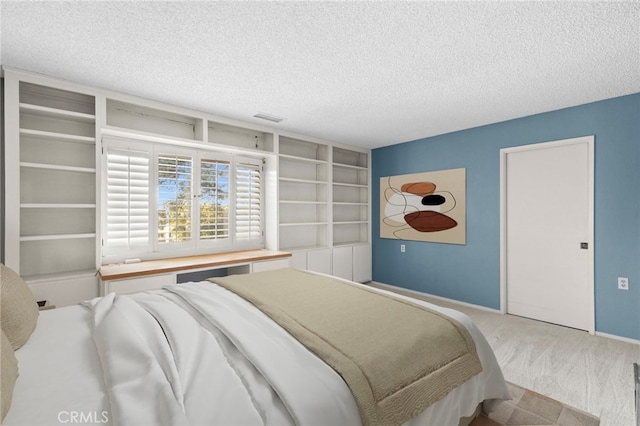 bedroom featuring carpet, visible vents, baseboards, and a textured ceiling