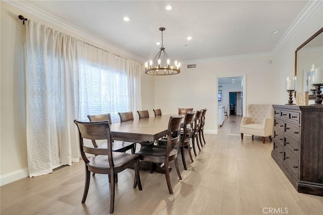 dining area with crown molding, a chandelier, and light wood-type flooring