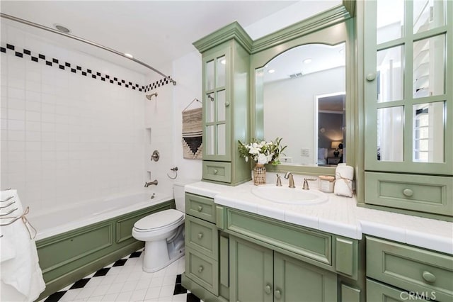 full bathroom featuring tiled shower / bath combo, vanity, tile patterned floors, and toilet