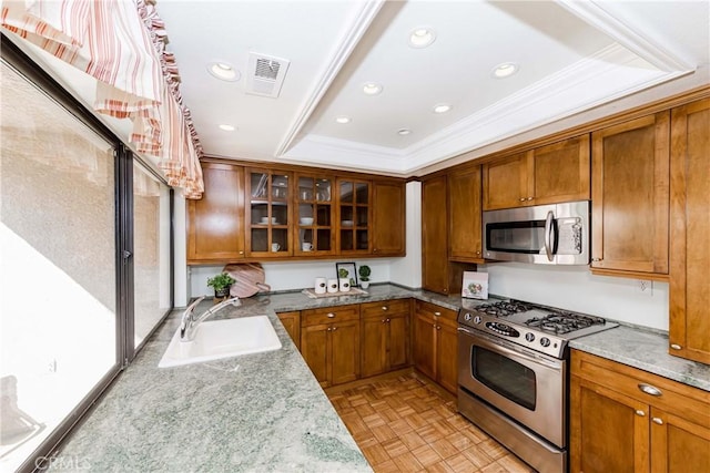 kitchen featuring stainless steel appliances, a raised ceiling, sink, and light parquet floors