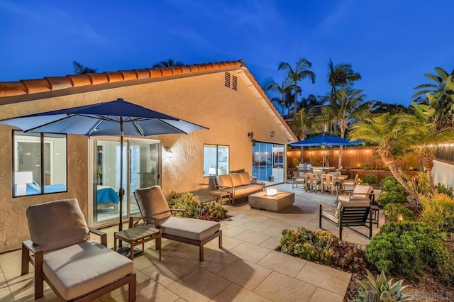 view of patio with an outdoor living space with a fire pit