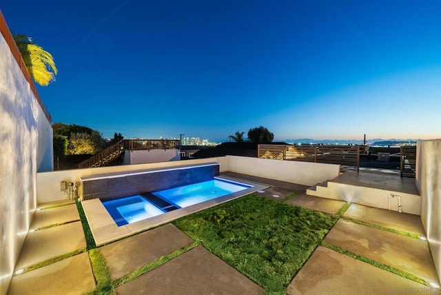 view of swimming pool featuring a patio area and an in ground hot tub