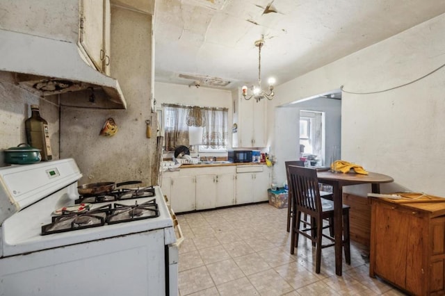 kitchen with pendant lighting, white cabinetry, sink, a notable chandelier, and gas range gas stove