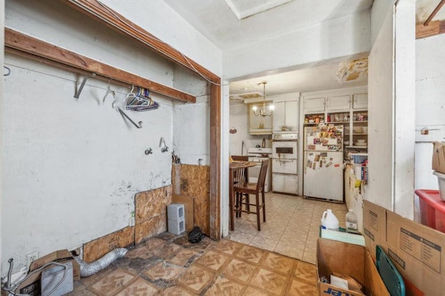 kitchen with hanging light fixtures, white appliances, and a chandelier