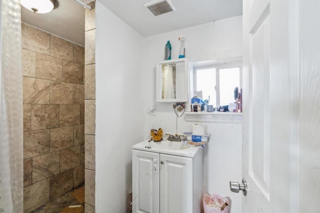 bathroom with vanity and a shower