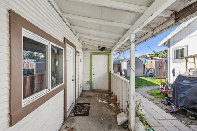 view of patio / terrace with a storage unit and a grill