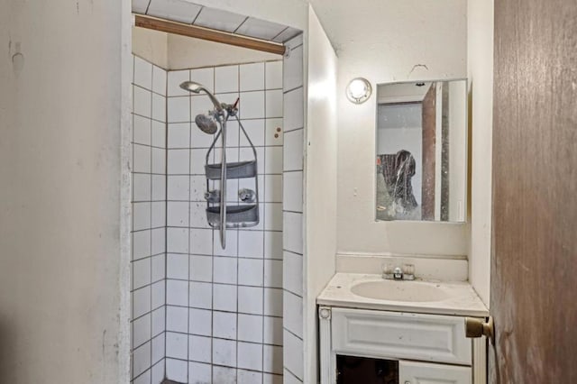 bathroom featuring tiled shower and vanity