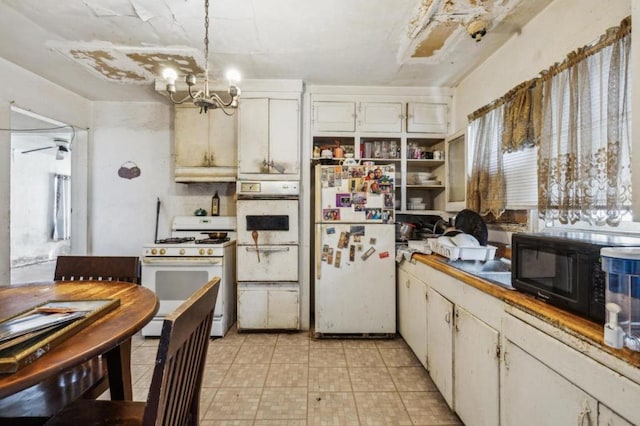 kitchen with hanging light fixtures, white cabinetry, a chandelier, and white appliances