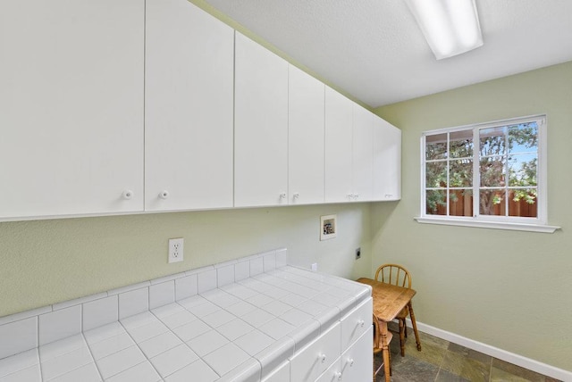 washroom featuring electric dryer hookup, washer hookup, and cabinets