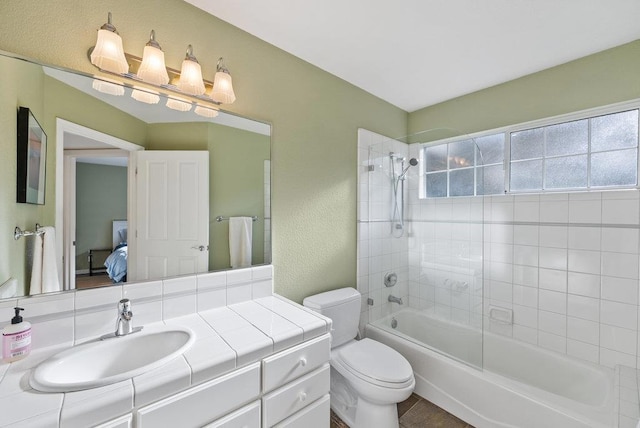 full bathroom with tiled shower / bath combo, vanity, and toilet