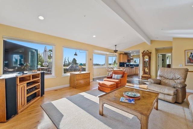 living room with lofted ceiling with beams, plenty of natural light, and light hardwood / wood-style flooring