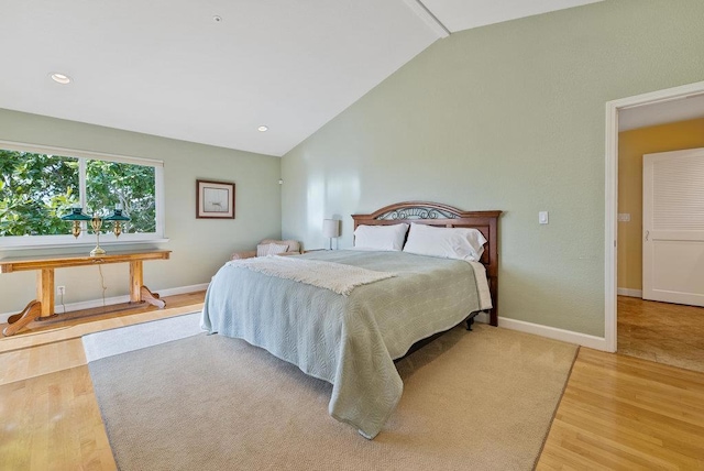 bedroom with vaulted ceiling and light hardwood / wood-style flooring