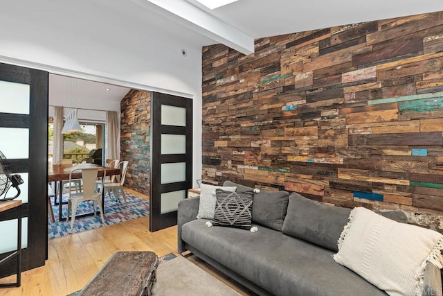 living room with vaulted ceiling with beams and light wood-type flooring