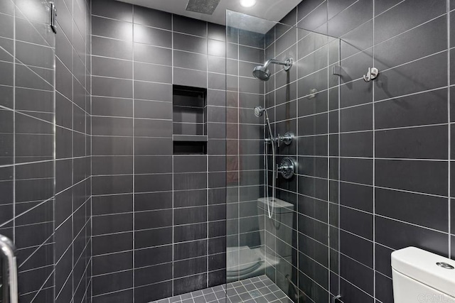 bathroom featuring toilet and tiled shower