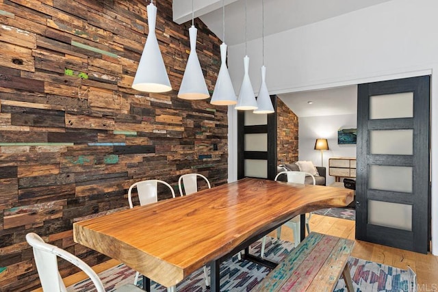 dining area featuring lofted ceiling and light hardwood / wood-style floors