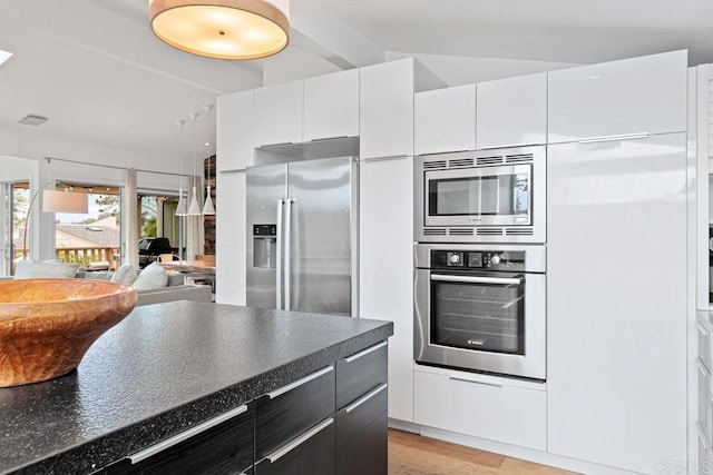 kitchen with stainless steel appliances, lofted ceiling, white cabinets, and light wood-type flooring