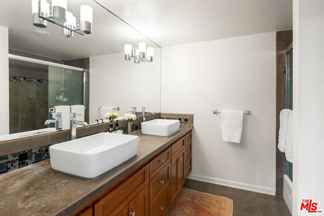 bathroom with a shower with door, vanity, and an inviting chandelier