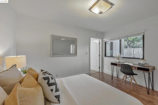 bedroom with dark hardwood / wood-style floors