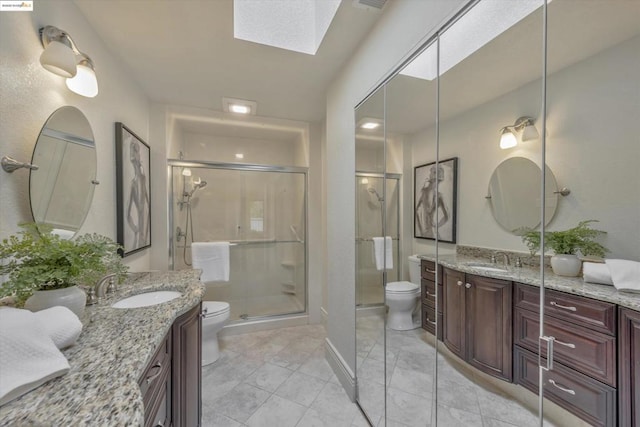 bathroom with a skylight, a shower with door, and toilet