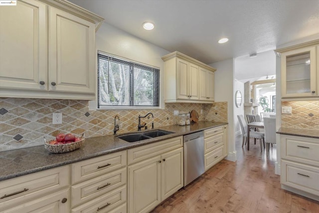 kitchen featuring light hardwood / wood-style floors, dishwasher, sink, and cream cabinetry