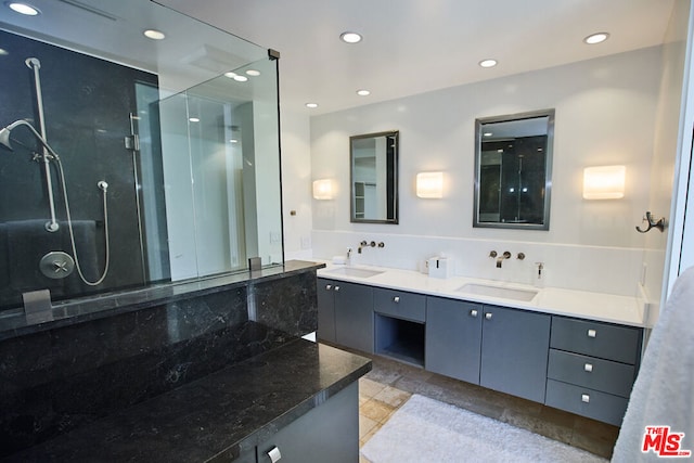 bathroom with walk in shower, vanity, and tile patterned flooring