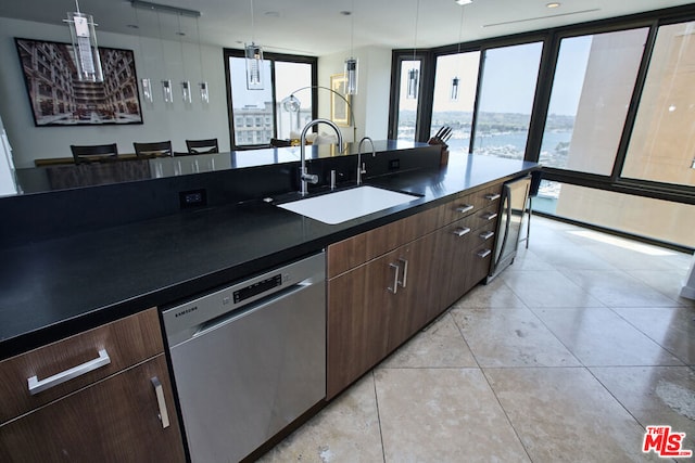 kitchen featuring dark brown cabinetry, sink, hanging light fixtures, light tile patterned floors, and stainless steel dishwasher