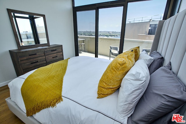 bedroom with a water view and wood-type flooring