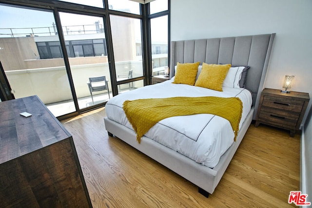 bedroom featuring multiple windows and light hardwood / wood-style flooring