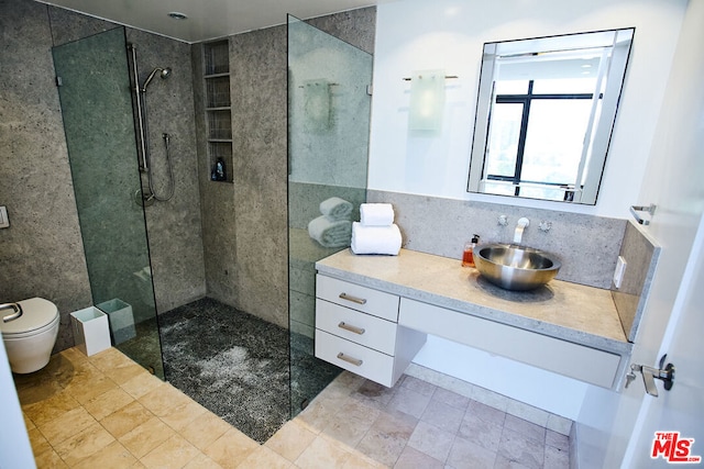 bathroom with vanity, tiled shower, decorative backsplash, and toilet