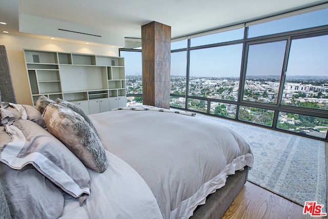 bedroom featuring expansive windows and hardwood / wood-style floors