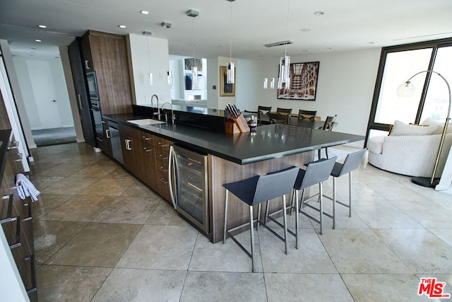 kitchen featuring pendant lighting, sink, dark brown cabinets, and a kitchen bar