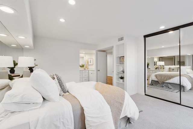 carpeted bedroom featuring connected bathroom and a closet