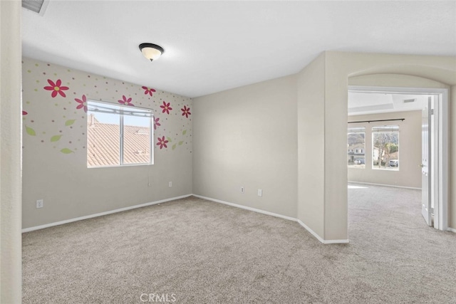 carpeted spare room with visible vents and baseboards