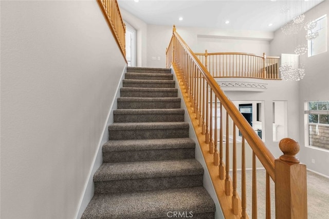 staircase with baseboards, carpet, a high ceiling, a chandelier, and recessed lighting