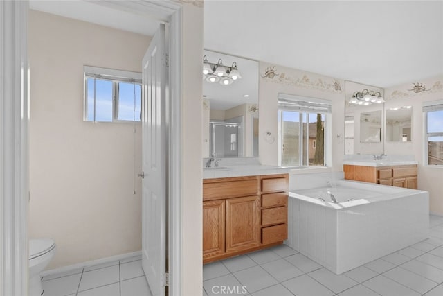 full bathroom with a stall shower, two vanities, a garden tub, tile patterned flooring, and a sink