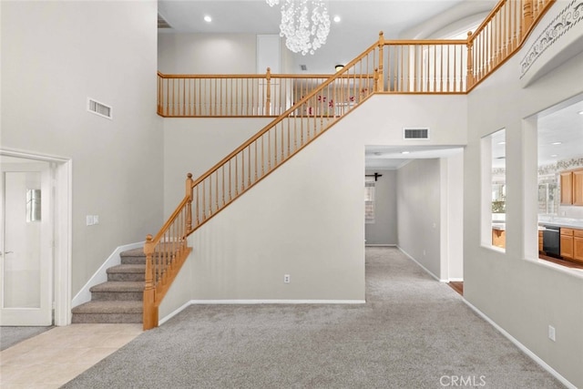 stairway with carpet flooring, a chandelier, and a high ceiling