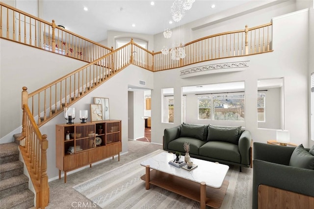 carpeted living room featuring a notable chandelier and a towering ceiling