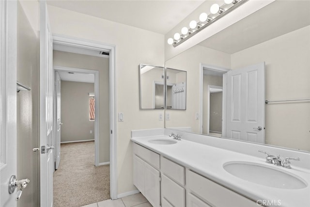 full bathroom featuring double vanity, baseboards, a sink, and tile patterned floors