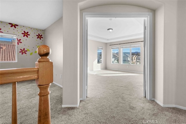 hall featuring carpet and baseboards