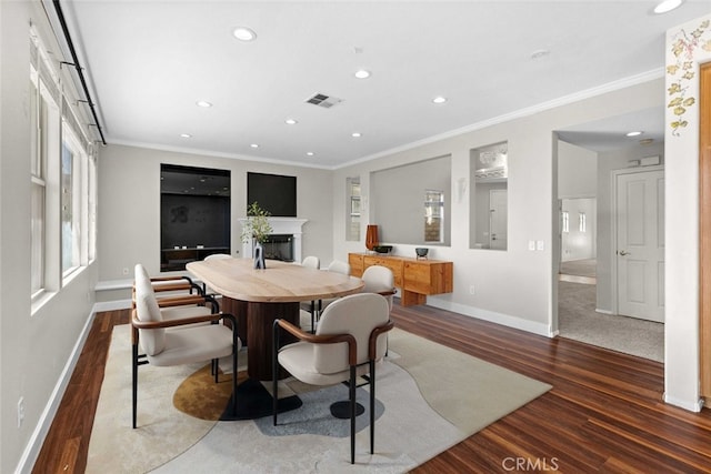 dining room with crown molding, a fireplace, baseboards, and wood finished floors