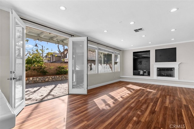 unfurnished living room with recessed lighting, visible vents, plenty of natural light, and a fireplace with raised hearth